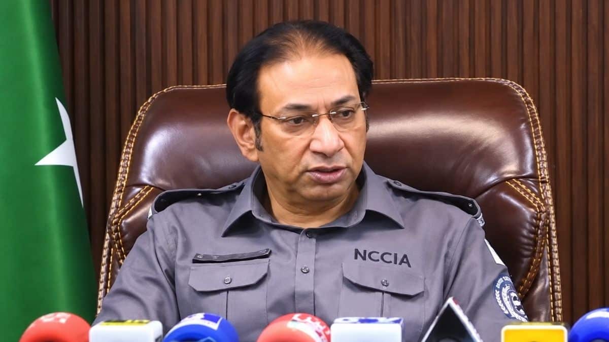 An NCCIA officer in uniform speaking to reporters at a press conference