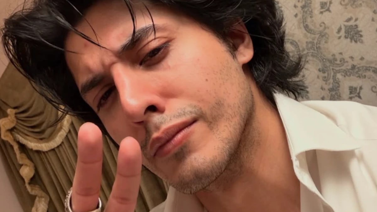 Danyal Zafar in a white shirt making a peace sign in a selfie