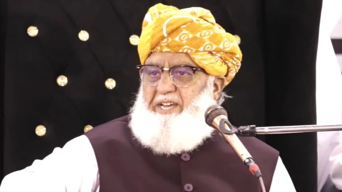 JUI-F chief Maulana Fazlur Rehman speaking into a microphone at a gathering
