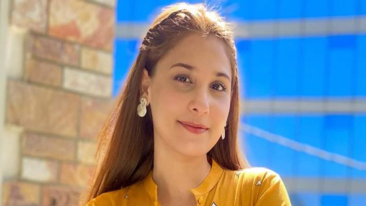 Hina Altaf in a mustard top, smiling outdoors