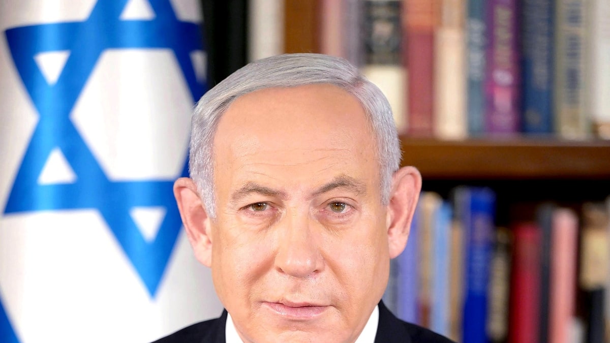Benjamin Netanyahu in front of an Israeli flag and bookshelves