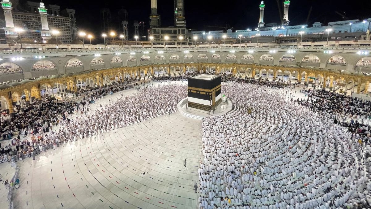 Pilgrims in white ihram around the Kaaba at the Grand Mosque in Makkah at night
